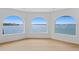 Spacious living room with waterfront views through arched windows at 2250 Donato Dr, Belleair Beach, FL 33786