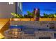 Well-equipped outdoor kitchen featuring stainless steel grills, a mosaic backsplash, and sophisticated decor at 2250 Donato Dr, Belleair Beach, FL 33786