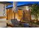 Relaxing outdoor seating area with lounge chairs, a side table, wooden privacy fence, and tasteful landscape lighting at 2250 Donato Dr, Belleair Beach, FL 33786