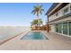 A modern pool with a waterfront view and lush landscaping enhances the outdoor living space at 2250 Donato Dr, Belleair Beach, FL 33786
