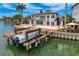 Gorgeous waterfront home featuring a boat dock, private pool, and lush tropical landscaping at 2250 Donato Dr, Belleair Beach, FL 33786