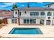 Back of house featuring a gorgeous pool, steps, tan tiled patio, and access to the balcony above at 2250 Donato Dr, Belleair Beach, FL 33786