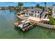 Gorgeous waterfront home featuring a boat dock, private pool, and lush tropical landscaping at 2250 Donato Dr, Belleair Beach, FL 33786