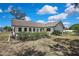 Landscaped backyard featuring a charming single-Gathering home with a blue door and several windows at 2360 Sutton Pl, Spring Hill, FL 34608