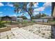 Backyard with a stone tiled patio, mature tree, and white fence at 2360 Sutton Pl, Spring Hill, FL 34608