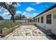 Backyard with a stone tiled patio, mature tree, and white fence at 2360 Sutton Pl, Spring Hill, FL 34608