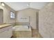 Bright bathroom with a soaking tub, tiled shower enclosure, and a single window at 2360 Sutton Pl, Spring Hill, FL 34608
