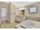 This bathroom features a soaking tub and a large vanity with updated lighting at 2360 Sutton Pl, Spring Hill, FL 34608