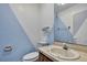 Bathroom featuring a sink, toilet, and blue accent wall at 2360 Sutton Pl, Spring Hill, FL 34608