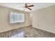This bedroom features a ceiling fan and new gray laminate flooring at 2360 Sutton Pl, Spring Hill, FL 34608