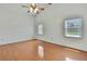 A serene bedroom includes wood flooring and bright windows at 2360 Sutton Pl, Spring Hill, FL 34608