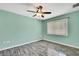 This bedroom features updated flooring, a ceiling fan, and a large window at 2360 Sutton Pl, Spring Hill, FL 34608