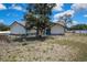 Exterior shot showing the front of the house with a light blue double door and a large shade tree at 2360 Sutton Pl, Spring Hill, FL 34608