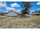 Exterior shot showing the front of the house with a light blue door and a large shade tree at 2360 Sutton Pl, Spring Hill, FL 34608