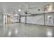 Spacious garage with painted floor, two doors, and high ceilings with fans at 2360 Sutton Pl, Spring Hill, FL 34608