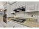 Modern kitchen featuring granite countertops, white cabinets, and black appliances at 2360 Sutton Pl, Spring Hill, FL 34608