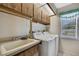 Bright laundry room featuring tile floors, a window, and washer and dryer at 2360 Sutton Pl, Spring Hill, FL 34608