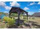 A wooden pergola structure sits in the backyard of a charming property with green shrubs around it at 2360 Sutton Pl, Spring Hill, FL 34608
