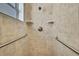 A tiled shower enclosure with grab bars and a modern shower head fixture at 2360 Sutton Pl, Spring Hill, FL 34608