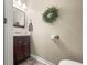 Bathroom with wood vanity, mirror, and a decorative green wreath on the wall at 2529 Harn Blvd # 2, Clearwater, FL 33764
