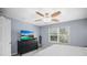 Bright bedroom featuring a ceiling fan, window, dresser with TV, and neutral walls at 2529 Harn Blvd # 2, Clearwater, FL 33764