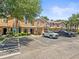 A row of tan townhomes with well-manicured lawns, a street lined with parked vehicles, and a beautiful, blue sky at 2529 Harn Blvd # 2, Clearwater, FL 33764