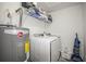 Efficient laundry room with a washing machine, dryer, shelving, and water heater at 2529 Harn Blvd # 2, Clearwater, FL 33764