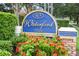 A community sign surrounded by red flowers marking the entrance to Waterford community at 2529 Harn Blvd # 2, Clearwater, FL 33764