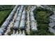 An aerial view of long rows of townhomes, some surrounded by trees, and parking areas at 26514 Chimney Spire Ln, Wesley Chapel, FL 33544