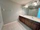 Bright bathroom with double sink vanity, decorative light fixture, and tile floors at 26514 Chimney Spire Ln, Wesley Chapel, FL 33544