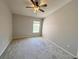 Spacious bedroom featuring a ceiling fan and a sunlit window at 26514 Chimney Spire Ln, Wesley Chapel, FL 33544