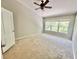 Neutral bedroom with a ceiling fan and natural light from the large window at 26514 Chimney Spire Ln, Wesley Chapel, FL 33544