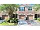 Beautiful townhome showcasing a private garage, arched entryway, and meticulously kept landscaping at 26514 Chimney Spire Ln, Wesley Chapel, FL 33544