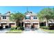 Charming townhome featuring a private garage, arched entryway, and neatly kept landscaping at 26514 Chimney Spire Ln, Wesley Chapel, FL 33544