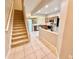 An open kitchen with stainless steel appliances and a tile floor viewed from the stairs at 26514 Chimney Spire Ln, Wesley Chapel, FL 33544
