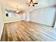 Bright and airy living room featuring wood-look floors, ceiling fan, and open layout to the kitchen at 26514 Chimney Spire Ln, Wesley Chapel, FL 33544