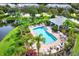 Beautiful pool and pool house with palm trees, lounge chairs and landscaping next to a pond at 26514 Chimney Spire Ln, Wesley Chapel, FL 33544