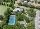 This aerial view features a tennis court, basketball court, playground, community pool, and green space in a neighborhood at 32201 Brookstone Dr, Wesley Chapel, FL 33545