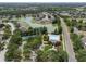Community aerial view featuring a lake, pool, tennis court, and playground surrounded by green spaces and residential homes at 32201 Brookstone Dr, Wesley Chapel, FL 33545