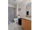 Bathroom with a wooden cabinet vanity and a black and white checkered shower curtain at 32201 Brookstone Dr, Wesley Chapel, FL 33545