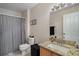 Neutral bathroom featuring granite counters, checkered shower curtain, and tile flooring at 32201 Brookstone Dr, Wesley Chapel, FL 33545