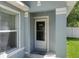 Close-up of the home's entrance featuring a welcome mat, storm door, and neutral exterior at 32201 Brookstone Dr, Wesley Chapel, FL 33545