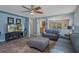 Open-concept living room with tile flooring, a ceiling fan, and a view into the kitchen at 32201 Brookstone Dr, Wesley Chapel, FL 33545