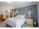 Main bedroom with blue accent wall, full bed, and a view into the ensuite bathroom at 32201 Brookstone Dr, Wesley Chapel, FL 33545