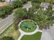 Overhead view of a community playground surrounded by mature trees, lush landscaping, and green space for children to enjoy at 32201 Brookstone Dr, Wesley Chapel, FL 33545