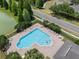 This aerial view showcases a heart-shaped pool with lounge chairs, and lush landscaping with a nearby pond at 32201 Brookstone Dr, Wesley Chapel, FL 33545