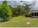 Lush backyard featuring mature trees, a pond, and plenty of green space adjacent to the home at 333 Bay Pl, Safety Harbor, FL 34695