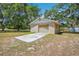 Detached garage with a concrete driveway and an aged rollup door at 34125 Chancey Rd, Wesley Chapel, FL 33543