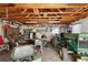 Garage interior full of mowers and tools and with an exposed wooden ceiling at 34125 Chancey Rd, Wesley Chapel, FL 33543