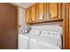 Bright laundry room with washer and dryer and overhead cabinets at 34125 Chancey Rd, Wesley Chapel, FL 33543